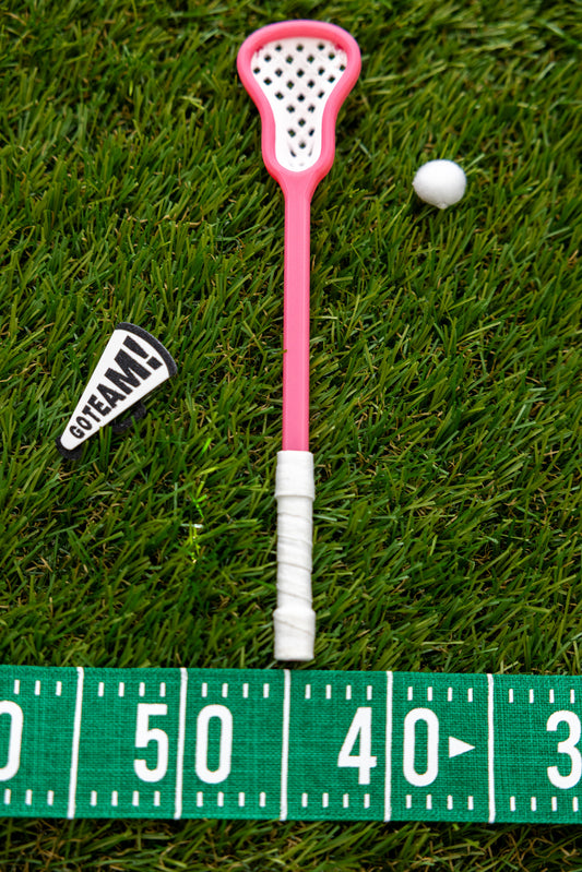 A miniature pink lacrosse stick with a white mesh head and white wrapped handle.